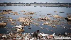 Polluted Yamuna River with floating waste highlighting water pollution and its impact on human health and DNA.